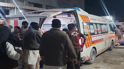 Rescue workers approach an ambulance arrive with the injured victims of suicide bombing at a wedding ceremony, at a hospital in Dera Ismail Khan, Pakistan, Friday, Jan. 23, 2026. (AP Photo/Kashif Naveed)