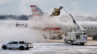 Snow and ice is cleared at Ronald Reagan Washington National Airport, Monday morning, Jan. 26, 2026, in Arlington, Va. (AP Photo/Julia Demaree Nikhinson)
