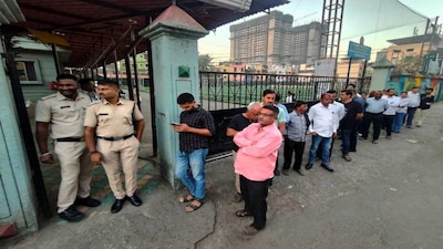 Police personnel stand guard as people wait in a queue to cast votes during the Navi Mumbai Municipal Corporation (NMMC) elections, at a polling station at Kopar Khairane, in Navi Mumbai, Maharashtra. (PTI)