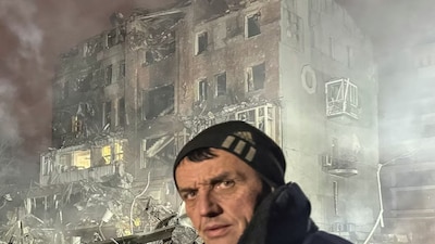 A resident stands at the site of an apartment building hit by a Russian air strike, amid Russia's attack on Ukraine, in Kharkiv, Ukraine January 2, 2026. REUTERS