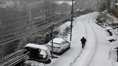 A man walks through snow amid fresh snowfall at Bhaderwah, in Doda district, Jammu and Kashmir. (PTI)