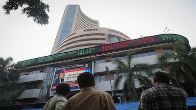 People watch a large screen displaying India's benchmark share index on the facade of the Bombay Stock Exchange (BSE) building in Mumbai October 16, 2014. Indian shares fell for a second consecutive session on Thursday, as companies seen most exposed to the global economy such as Hindalco Industries and Sesa Sterlite declined tracking a downturn in global markets. REUTERS/Shailesh Andrade (INDIA - Tags: BUSINESS)