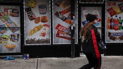 A woman walks by a makeshift memorial for a 30-year-old man who was shot and killed inside a Harlem bodega and smoke shop Sunday night according to police, along West 142nd street in the Harlem neighborhood of New York City, U.S., December 5, 2023. REUTERS/Shannon Stapleton