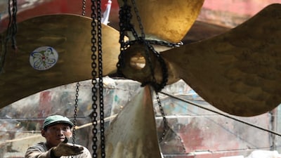 A worker pulls the chain to lift a propeller while he repairs a ship at a shipyard in North Jakarta, Indonesia, July 8, 2024. REUTERS/Ajeng Dinar Ulfiana
