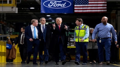 FILE PHOTO: U.S. President Donald Trump walks with Treasury Secretary Scott Bessent, Bill Ford, Executive Chairman of Ford, Jim Farley, CEO of Ford and Corey Williams, Ford River Rouge Plant Manager, during President Trump's visit to a Ford production center in Dearborn, Michigan, U.S., January 13, 2026. REUTERS/Evelyn Hockstein/File Photo