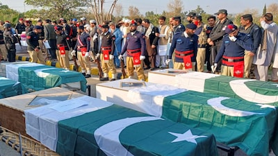 Police officers and residents gather beside Pakistani flag-draped coffins of police officers who were killed following a terrorist attack on a police vehicle, during a funeral in Kohat, in Khyber Pakhtunkhwa province, Pakistan, February 24, 2026. REUTERS/Syed Basit
