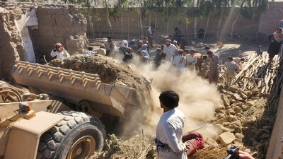 FILE PHOTO: Residents gather as machinery clears the debris of a damaged house, following the Pakistani air strikes, in Nangarhar, Afghanistan, February 22, 2026. REUTERS/Stringer/File Photo