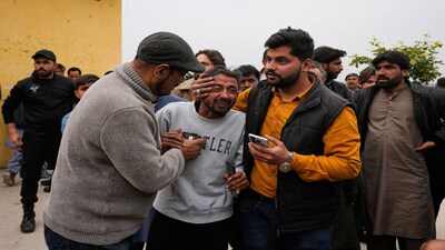 People comfort a man, center, mourning over the death of his relative, close to the site of a bomb explosion at a Shiite mosque, in Islamabad, Pakistan, Friday, Feb. 6, 2026. (AP Photo/Anjum Naveed)