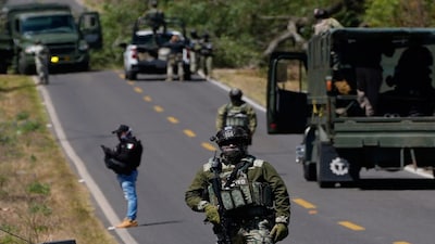 A soldier clears a roadblock on a road leading to Tapalpa, Mexico, Monday, Feb. 23, 2026, a day after the Mexican army killed Jalisco New Generation Cartel leader Nemesio Oseguera Cervantes, known as "El Mencho." (AP Photo/Marco Ugarte)