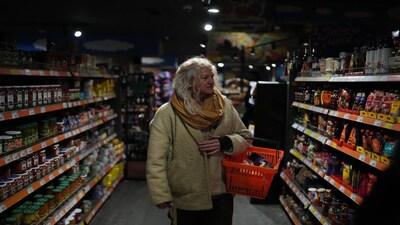 Tetiana Khimion, 47, a dance teacher before Russia's full-scale invasion, now a sniper in the Ukrainian army, shops for groceries in Kyiv, Ukraine, Sunday, Feb. 22, 2026. (AP Photo/Sergei Grits)