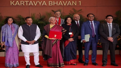 Finance Minister Nirmala Sitharaman holds a folder bearing the Government of India's emblem, as she poses with her officials while leaving her office to present the annual federal budget in parliament, in New Delhi. (Reuters)