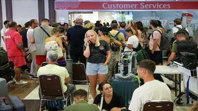 Stranded passengers wait near Emirates Airways customer service office at I Gusti Ngurah Rai International Airport after flights to Doha, Dubai, and Abu Dhabi were cancelled following strikes on Iran launched by the United States and Israel, in Kuta, Bali, Indonesia, March 1, 2026. REUTERS/Johannes Christo