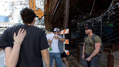 Hunter Wilder, hugs a Buford's employee who did not want to be named, as Stephen Lax, a member of the Buford's security team, looks on as the group of friends reconnect following the recent mass shooting at the roadhouse-style bar in Austin, Texas, U.S., March 2, 2026. (Image Reuters)