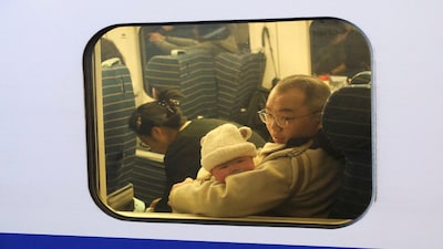 FILE PHOTO: A baby looks out a window of the train during the Spring festival travel rush ahead of the Lunar New Year, at Shanghai Hongqiao railway station in Shanghai, China, January 24, 2025.  REUTERS/Go Nakamura/File Photo