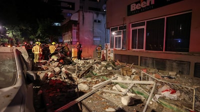 Emergency personnel inspect damage in a building following an Iranian projectile strike, amid the U.S.-Israeli conflict with Iran, in central Israel, March 18, 2026. REUTERS/Nir Elias