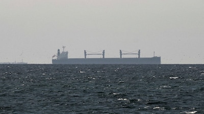 FILE PHOTO: A cargo ship in the Gulf, near the Strait of Hormuz, as seen from northern Ras al-Khaimah, near the border with Oman’s Musandam governance, amid the U.S.-Israeli conflict with Iran, in United Arab Emirates, March 11, 2026. REUTERS/Stringer/File Photo REFILE - CORRECTING "TANKER" TO "CARGO SHIP" AND REMOVING ACTION "SAILS".