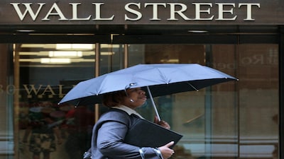 FILE PHOTO: A woman walks through the rain on Wall Street in New York, August 16, 2011. REUTERS/Brendan McDermid/File Photo