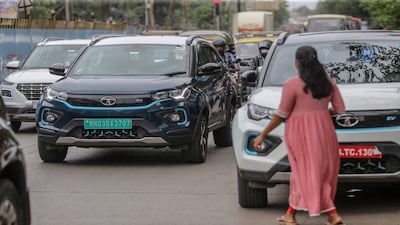A Tata Motors Ltd. Nexon EV vehicle, center, drives past a company's dealership in Mumbai, India, on Tuesday, July 26, 2022. Tata Motors is expected to report results on July 27.