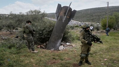 Israeli soldiers secure the site where an Iranian missile wreckage landed in the West Bank village of Kifl Haris Tuesday, March 24, 2026. (AP Photo/Majdi Mohammed)