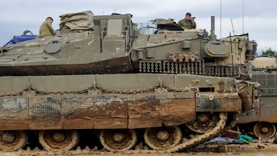 Israeli soldiers rest on a tank near the Israeli side of the border with Lebanon, amid escalating hostilities between Israel and Hezbollah, as the U.S.-Israeli conflict with Iran continues, in northern Israel, March 24, 2026. REUTERS/Tyrone Siu     TPX IMAGES OF THE DAY