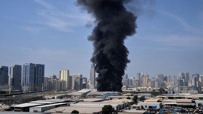 A black plume of smoke rises from a warehouse at the industrial area of Sharjah City in the United Arab Emirates following reports of Iranian strikes in Dubai, United Arab Emirates, Sunday, March 1, 2026. (AP Photo/Altaf Qadri)