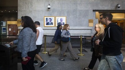 Federal workers enter the Ted Weiss Federal Building in the lower Manhattan area of New York October 17, 2013. Furloughed U.S. government workers returned to their jobs on Thursday, greeted with doughnuts, coffee, pep talks from Obama administration bosses and anxiety over whether they will face another shutdown threat in the new year. REUTERS/Brendan McDermid (UNITED STATES - Tags: POLITICS BUSINESS EMPLOYMENT)
