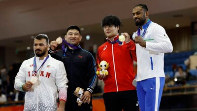 Asian Games - Aichi-Nagoya 2026 - Wrestling - Inae Sports Center, Nagoya, Japan - October 1, 2026 Gold medallist Japan's Yuri Nakazato celebrates on the podium after winning the men's greco-roman 97kg with silver medallist India's Nitesh and bronze medallists Iran's Mehdi Balihamzehdeh and Mongolia's Gankhuyag Ganbaatar REUTERS/Eloisa Lopez