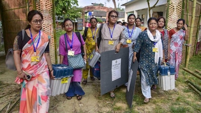 Officials carry election materials as they arrive at a polling station ahead of the Nagaon Lok Sabha by-election, in Nagaon district, Assam. (PTI Photo)
