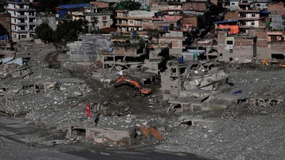 An excavator clears mud from damaged houses following deadly flash floods and a mudslide, in Nuwakot district, Nepal, September 21, 2026. REUTERS/Navesh Chitrakar