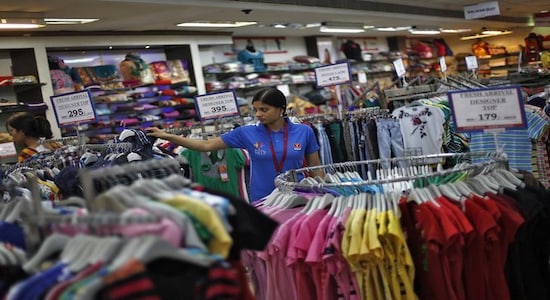 A sales assistant arranges clothing inside a retail store in New Delhi April 6, 2013. REUTERS/Adnan Abidi/Files