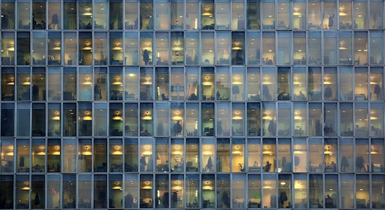 Lights are on as people work in their offices in a skyscraper in downtown Milan, February 17, 2015. REUTERS/Stefano Rellandini/Files