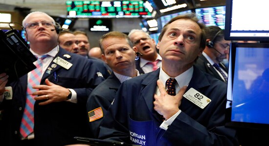 FILE- In this Nov. 14, 2018, file photo Dudley Devine, right, works with fellow traders on the floor of the New York Stock Exchange. The bull market in stocks started with the U.S. still reeling from the Great Recession in March 2009. The bull turns 10 this weekend, having survived threats such as a debt crisis in Europe (2011), a slowdown in the Chinese economy (2015-2016), and fears of inflation and rising interest rates in the U.S. (AP Photo/Richard Drew, File)