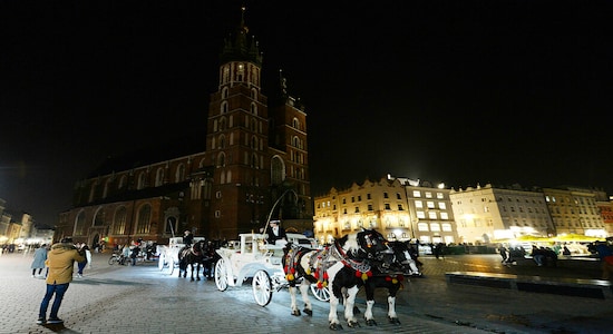 Lights are off for the global Earth Hour at the 14th-century red brick St. Mary's Basilica in the southern Renaissance city of Krakow, Poland, Saturday, March 30, 2019. The Earth Hour gesture calls for greater awareness and more sparing use of resources, especially fossil fuels that produce carbon gasses and lead to global warming. (AP Photo/Czarek Sokolowski)