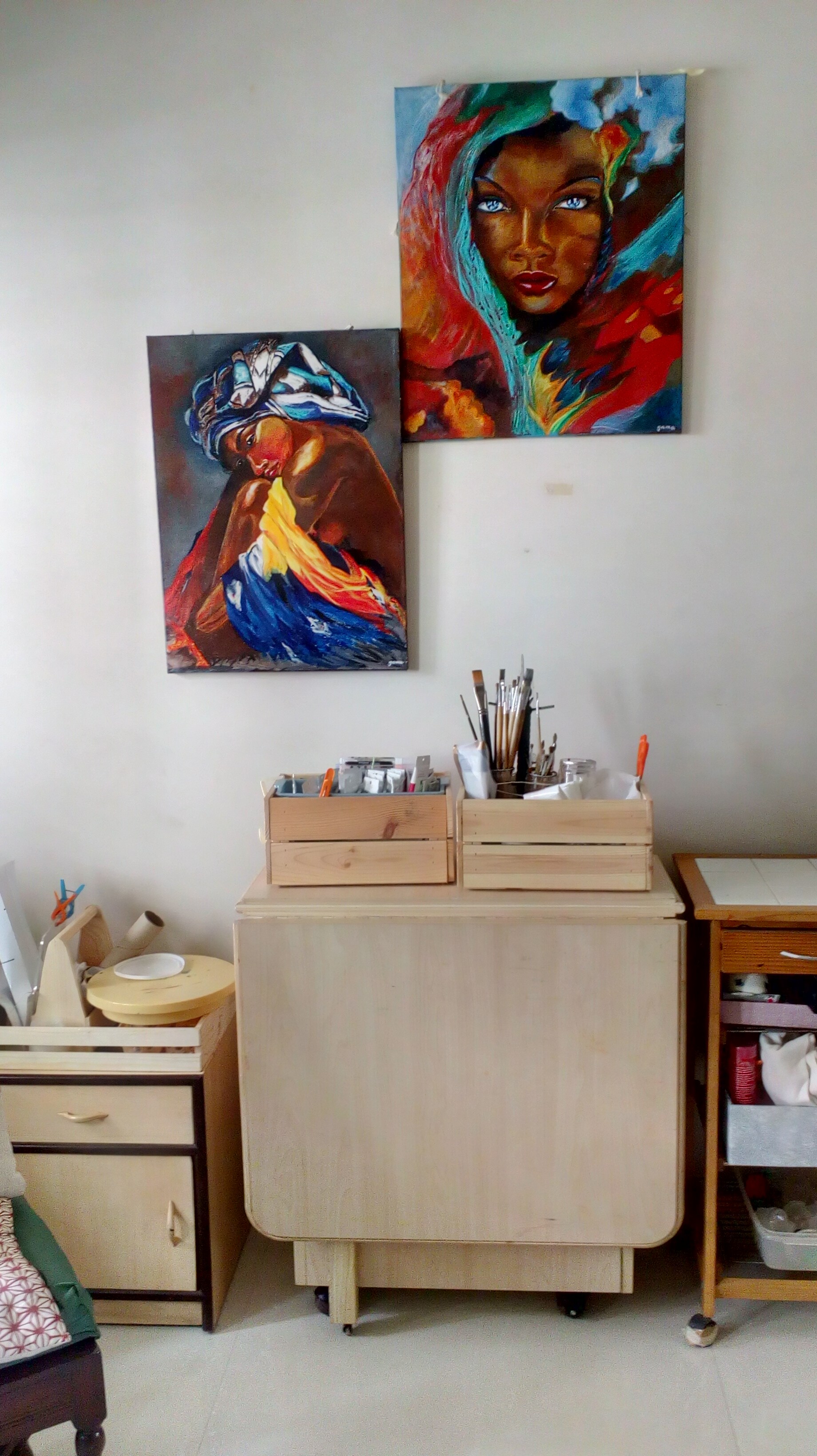 Two colourful paintings of African women hung inside Gama Lynn's home-studio