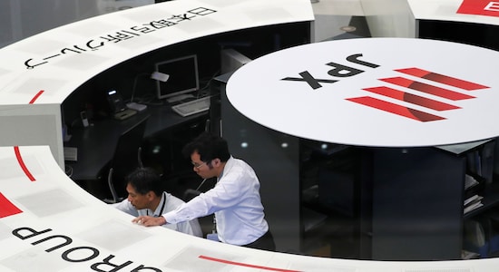 Employees of the Tokyo Stock Exchange (TSE) work at the bourse in Tokyo Japan Employees of the Tokyo Stock Exchange (TSE) work at the bourse in Tokyo Japan