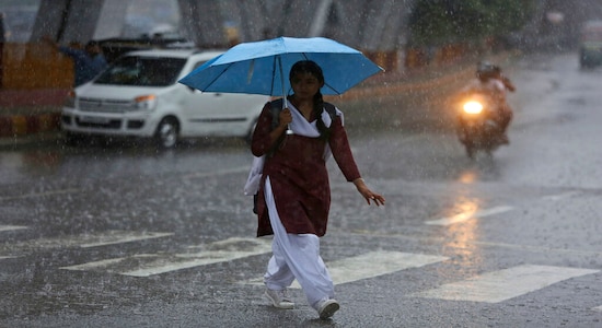 An Indian girl walks with an umbrella as it rains in Jammu, India, Saturday, July 27, 2019. The monsoon season in India lasts from June to September. (AP Photo/Channi Anand)