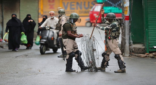 Indian paramilitary soldiers prepare to close off a street with barbwire in Srinagar, Kashmir. Indian paramilitary soldiers prepare to close off a street with barbwire in Srinagar, Kashmir.