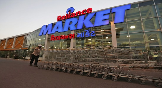 A worker pushes trolleys outside the Reliance Market superstore in the western Indian city of Ahmedabad