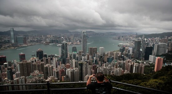 In this Sunday, Sept. 1, 2019 photo, a man sets up his camera in the Victoria Peak area to photograph Hong Kong's skyline. Life is not quite normal after three months of steady protests in the Asian financial center - and yet normal life goes on, as it must, for the city’s 7.4 million residents. (AP Photo/Jae C. Hong)