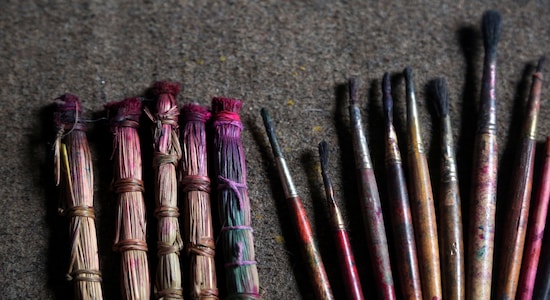 In this July 31, 2019, photo, handmade traditional brushes, left, are lined up along with modern paint brushes at the residence of Chitrakar couple Tej Kumari and Purna, in Bhaktapur, Nepal. Chitrakar families in the Nepalese capital of Kathmandu were renowned traditional painters and sculptors who depicted gods and goddesses on temples, masks of Hindu deities and posters for various religious celebrations. For the Chitrakar couple it is a struggle to keep the dying art alive against the modern mass produced prints. (AP Photo/Niranjan Shrestha)