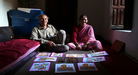 In this July 31, 2019, photo, Chitrakar couple Tej Kumari and Purna, left, pose for photographs at their residence in Bhaktapur, Nepal. Chitrakar families in the Nepalese capital of Kathmandu were renowned traditional painters and sculptors who depicted gods and goddesses on temples, masks of Hindu deities and posters for various religious celebrations. For the Chitrakar couple it is a struggle to keep the dying art alive against the modern mass produced prints. (AP Photo/Niranjan Shrestha)