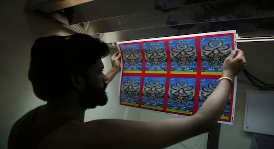In this Aug. 2, 2019, photo, a Nepalese man checks newly printed posters getting ready ahead of Naag panchami festival at a printing press in Kathmandu, Nepal. The art and tradition of Nepal’s Chitrakar families, who depicted gods and goddesses on temples, masks of Hindu deities and posters for various religious celebrations is dying because of mass machine printed posters and card-size pictures of gods that are cheaper and more popular. (AP Photo/Niranjan Shrestha)