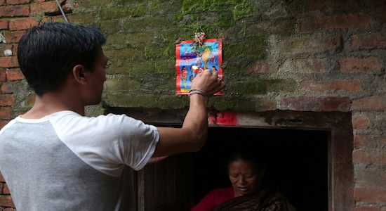 In this Aug. 5, 2019, photo, a Nepalese man displays a machine made painting on his house door during Naag Panchami festival in Bhaktapur, Nepal. The art and tradition of Nepal’s Chitrakar families, who depicted gods and goddesses on temples, masks of Hindu deities and posters for various religious celebrations is dying because of mass machine printed posters and card-size pictures of gods that are cheaper and more popular. (AP Photo/Niranjan Shrestha) In this Aug. 5, 2019, photo, a Nepalese man displays a machine made painting on his house door during Naag Panchami festival in Bhaktapur, Nepal. The art and tradition of Nepal’s Chitrakar families, who depicted gods and goddesses on temples, masks of Hindu deities and posters for various religious celebrations is dying because of mass machine printed posters and card-size pictures of gods that are cheaper and more popular. (AP Photo/Niranjan Shrestha)