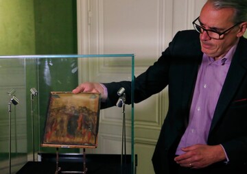 FILE - In this Tuesday, Sept. 24, 2019 filer, art expert Stephane Pinta takes out of a glass case a painting by Italian master Cimabue in Paris. A masterpiece attributed to the 13th-century Italian painter Cimabue that was discovered in an elderly French woman's kitchen is expected to sell for millions at auction. Stephane Pinta, a painting specialist with the Turquin gallery in Paris, said an auctioneer spotted the painting while inspecting the woman's house in Compiegne in northern France and suggested she bring it to experts for an evaluation. (AP Photo/Michel Euler)