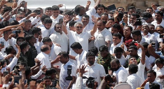 In this Monday, Nov. 18, 2019, file photo, Sri Lanka's newly elected president Gotabaya Rajapaksa, center, greets people as he leaves after the swearing in ceremony held at the 140 B.C Ruwanweli Seya Buddhist temple in ancient kingdom of Anuradhapura in north central Sri Lanka. The former defense official credited with ending a long civil war was Monday sworn in as Sri Lanka's seventh president after comfortably winning last Saturday's presidential election. (AP Photo/Eranga Jayawardena, File)