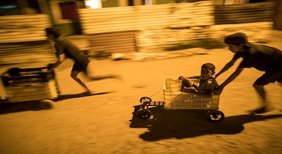 In this Tuesday, Nov.19, 2019 photo, children race in makeshift go-carts in the &quot;Altos de Milagros Norte&quot; neighborhood of Maracaibo, Venezuela. Nationwide, an estimated 4.5 million residents have fled Venezuela, most going to nearby Colombia, Peru and Ecuador. They search for better jobs to send money home, but they often confront backlash and hardships as their numbers steadily grow. (AP Photo/Rodrigo Abd)