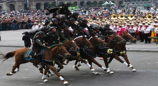 In this Wednesday, Nov. 20, 2019 photo, soldiers form a pyramid atop a team of horses during a parade marking the 109th anniversary of the Mexican Revolution, at the Zocalo in Mexico City. More than a 1,000 participants dressed in time period clothing and acted out historical scenes. (AP Photo/Marco Ugarte)