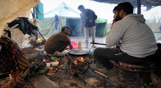 In this Wednesday, Nov. 20, 2019, photograph, migrants cook at the Vucjak refugee camp outside Bihac, northwestern Bosnia. (AP Photo/Kemal Softic)