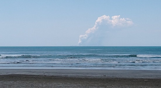 Smoke bellows from Whakaari, also known as White Island, volcano as it erupts, as seen from a distance at Ohope beach in New Zealand, December 9, 2019, in this image obtained via social media. @DONNACHA via REUTERS