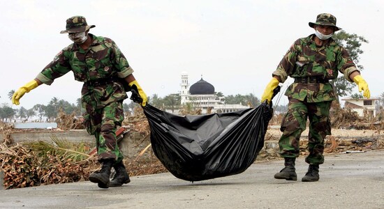 FILE PHOTO: Indonesian soldiers remove a body from the village of Simpang Lima on the outskirts of Banda Aceh, on the Indonesian island of Sumatra, January 1, 2005. REUTERS/Darren Whiteside
